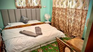 a bedroom with a bed with two towels on it at Al Hayat Guest House in Pahalgām