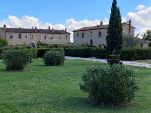 a house with a tree in the middle of a yard at English Garden Cortona in Cortona