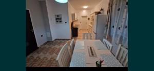 a dining room with a table and white chairs at Ferdinánd Guesthouse in Viile Satu Mare