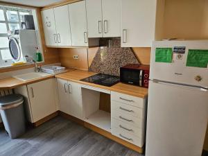 a kitchen with white cabinets and a white refrigerator at Albergue Azabache in Santiago de Compostela +23 photos