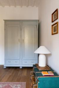 una habitación con un armario blanco y una lámpara en una maleta vieja en Inn Oltremare - appartamento di design a un passo dal centro e dal mare, en Livorno