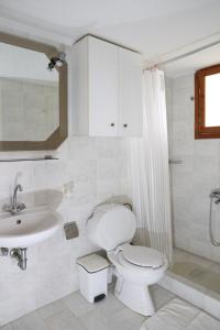 a white bathroom with a toilet and a sink at Babis Garden Salamina in Selínia +13 photos
