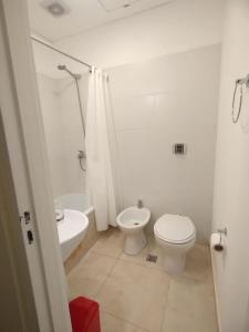a white bathroom with a toilet and a sink at La hora azul departamentos in Playas Doradas +79 photos