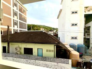 a building with a black roof on a balcony at Patong Canal Villa 204 in Patong Beach