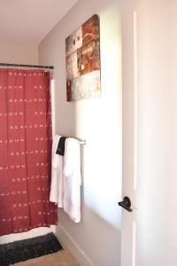 a bathroom with a shower with a red shower curtain at Downtown Aurora River Facing Gem in Aurora