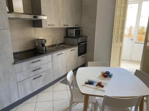 a kitchen with a table and a white table and chairs at Civico10, appartamento centrale con parcheggio e terrazzo in Piombino