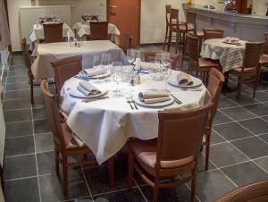 un comedor con mesas y sillas con mantel blanco en Hotel Wilgenhof, en Maaseik