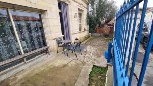 a table and chairs sitting outside of a building at Appart Hôtel Le Ptit Bec in Bègles