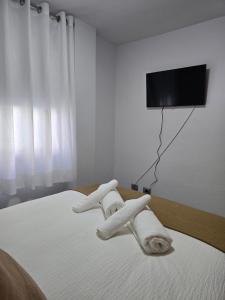 2 toallas en una cama con TV en la pared en Balcón de Puerto Naos, en Los Llanos de Aridane