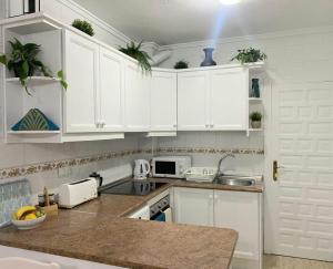 a white kitchen with white cabinets and a sink at La Florida Apartment Near Emerald Isle Complex in Orihuela Costa