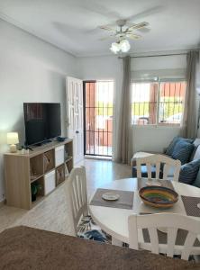 a living room with a table and a tv at La Florida Apartment Near Emerald Isle Complex in Orihuela Costa