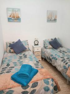 a bedroom with two beds and a clock on the wall at La Florida Apartment Near Emerald Isle Complex in Orihuela Costa +22 photos