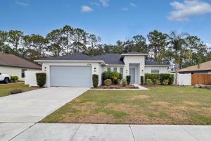 a large white house with a garage at Sunny Stay Orlando Queen Room 5 with Shared Bath in Orlando