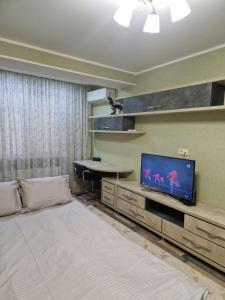キシナウにあるApartaments Sandraのベッド、テレビ、テーブルが備わる客室です。
