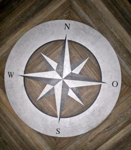 a clock on a wooden floor with a star at Apartmenthaus Hohenfels in Helgoland