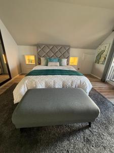 a bedroom with a large bed with a gray headboard at Studio privado com vista mar e montanha in Ponta do Sol