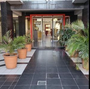 ein Gebäude mit Topfpflanzen vor einem Gebäude in der Unterkunft EL AMANECER - APART HUASI III in San Fernando del Valle de Catamarca + 2 Fotos