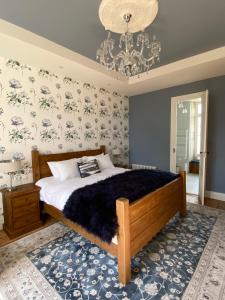 una camera da letto con un letto grande e un lampadario di La Montgrande Bed & Breakfast ad Aulnay