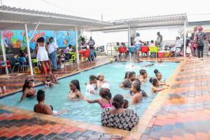 a group of people sitting in a swimming pool at The Space Guesthouse Mondlo in Mondlo