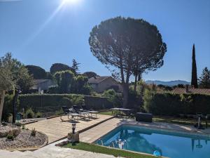 a swimming pool in a yard with a table and chairs at Studio cosy neuf calme -Parking Terrasse privée Piscine 5mn Gare TGV Aix et ZA Aix la Duranne 15 mn Aéroport Marseille in Cabriès