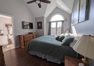 una camera da letto con un letto e un ventilatore a soffitto di Relaxing Condo on the River - NEW Air Hockey Table a Pigeon Forge Altre 19 foto