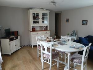 a dining room with a white table and chairs at Petite maison de vacances in Pléneuf-Val-André