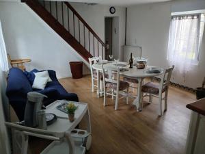 a living room with a table and chairs and a staircase at L'escale bretonne in Pléneuf-Val-André