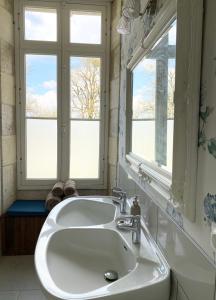 un lavandino bianco in un bagno con due finestre di La Montgrande Bed & Breakfast ad Aulnay
