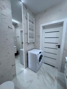 Una lavadora en un baño con puerta. en APARTAMENT Słoneczna 28 - POGORZELICA, en Pogorzelica