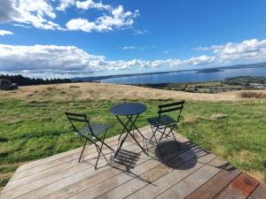 a table and two chairs sitting on a wooden deck at Aorangi Peak Cabins 8 by Tiny Away in Rotorua +15 photos