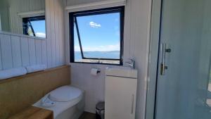 a small bathroom with a toilet and a window at Aorangi Peak Cabins 8 by Tiny Away in Rotorua