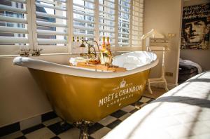 a yellow tub in a bathroom with a window at B&B Huisje Schaufeli in Apeldoorn