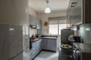 une cuisine équipée d'appareils en acier inoxydable et de placards gris dans l'établissement Xavier's Home, à Rabat 6 autres photos