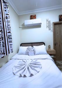 una camera da letto con un letto bianco e un grande copriletto bianco di The 5 Inn - Pyramids a Il Cairo