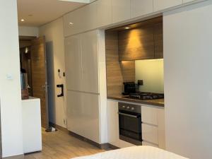 una cucina con armadietti bianchi e piano cottura di Studio One Dubai Marina - TIE Vacation Homes a Dubai