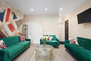 a living room with green couches and a glass table at OnSiteStays - Stylish 5 bedroom house with 3 bathrooms in Dartford