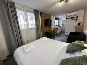 a hotel room with a large white bed and a chair at AH Rentals Suites in Vinarós