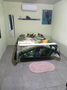 a bedroom with a bed with a comforter and a rug at Casa Shakira in Puerto Jiménez