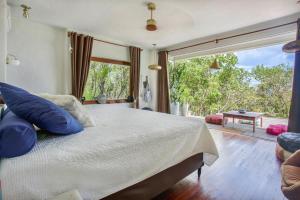 a bedroom with a large bed and a large window at Casa Dahomey in Pipa
