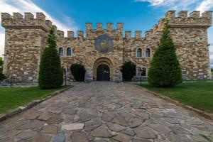 a large brick building with a stone driveway at Калоянова крепост in Arbanasi