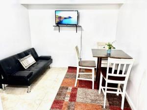 Roosevelt IslandPRIVATE 2 BR Apt with PRIVATE Backyard in LIC !!!的客厅里有一张黑色沙发和一张桌子