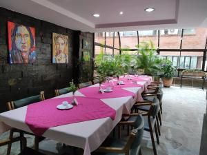 a long table in a room with tables and chairs at Gran Hotel in Medellín