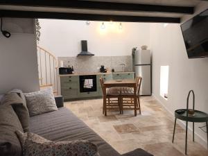 a living room with a couch and a table and a kitchen at Gîte de la Cheminée in Saint-Privat