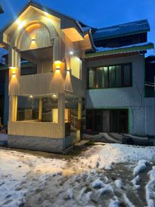 a house in the snow at night at Pine Brooke Pahalgam in Pahalgām
