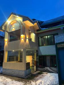 a large building with lights on it in the snow at Pine Brooke Pahalgam in Pahalgām