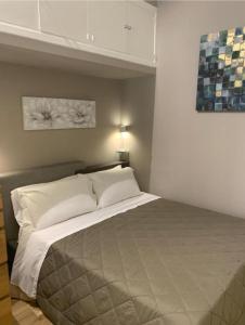 una camera da letto con un letto grande con cuscini bianchi di Sperlinga Suite a Palermo