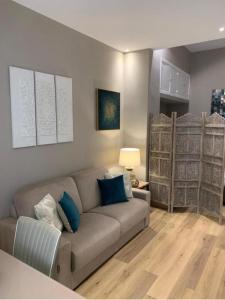un soggiorno con divano grigio e cuscini blu di Sperlinga Suite a Palermo