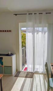 a living room with a sliding glass door to a patio at Le Stud Thau in Balaruc-les-Bains