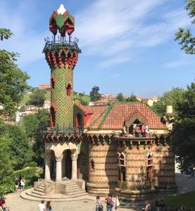 a building with a tower with people walking around it at La Aldea 3 , CENTRO de Comillas, Parking Público y vistas Universidad Pontificia in Comillas +10 photos