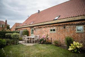 a brick house with a table and chairs in the yard at The Hayloft in Selby